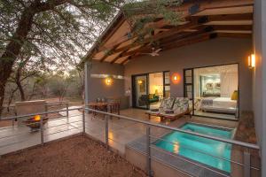 a house with a swimming pool on a balcony at Kruger's Keep - Luxury Couples Haven in Marloth Park
