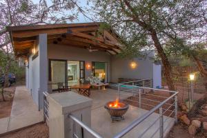a house with a fire pit on a patio at Kruger's Keep - Luxury Couples Haven in Marloth Park