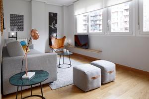 a living room with a couch and two stools at Mundaiz by FeelFree Rentals in San Sebastián