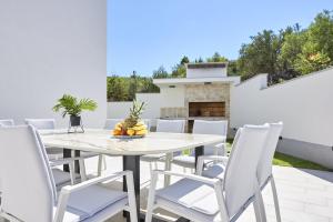 a patio with a white table and chairs at Luxury Villa Cor Mare with Pool in Trogir