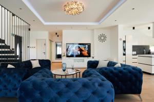 a living room with blue couches and a tv at Luxury Villa Cor Mare with Pool in Trogir