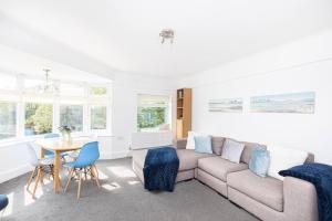 uma sala de estar com um sofá e uma mesa em Elmsway - Southbourne em Southbourne