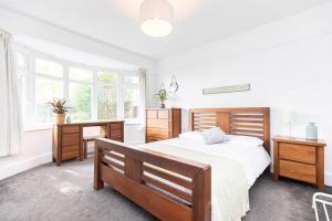 a bedroom with a large bed and two windows at Elmsway - Southbourne in Southbourne