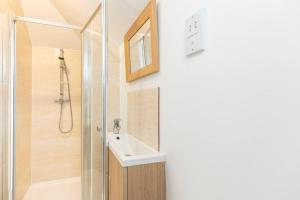 uma casa de banho com um lavatório e um chuveiro em Elmsway - Southbourne em Southbourne