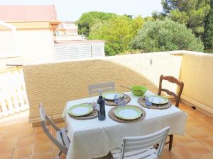 a table with a white table cloth on a patio at Apartment Les Romarines-5 by Interhome in Gruissan