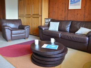 a living room with a leather couch and a coffee table at Apartment Mondzeu A258 by Interhome in Verbier