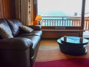ヴェルビエにあるApartment Mondzeu A258 by Interhomeの革張りのソファとコーヒーテーブルのあるリビングルーム