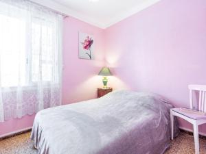 a bedroom with pink walls and a bed and a window at Holiday Home Canétoise Tixador by Interhome in Canet-en-Roussillon