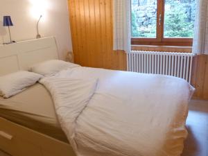 1 cama no hecha en un dormitorio con ventana en Apartment Centaure-3 by Interhome, en Les Rasses