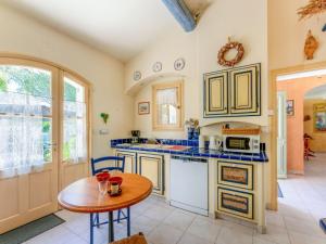 a kitchen with a wooden table and a small table with a table at Holiday Home La Noria by Interhome in Carpentras