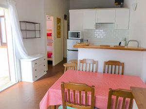 a kitchen with a table with a red tablecloth on it at Holiday Home Les Palombes-7 by Interhome in Lacanau-Océan