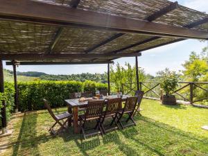 eine Terrasse mit einem Tisch und Stühlen unter einer Pergola in der Unterkunft Apartment Il Forno by Interhome in Monsanto
