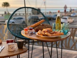 a table with a plate of bread and a bottle of beer at LE COTIER in Fécamp