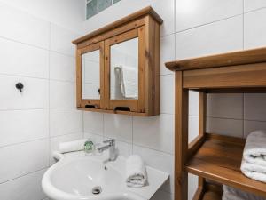 滨湖采尔斯坦萨里公寓的一间白色浴室，配有洗手池和镜子。