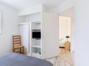 1 dormitorio con paredes blancas, 1 cama y espejo en Holiday Home Ty Fañch by Interhome, en Kerlouan