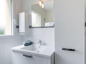 Un baño blanco con lavabo y espejo. en Holiday Home Ty Fañch by Interhome, en Kerlouan 16 fotos más