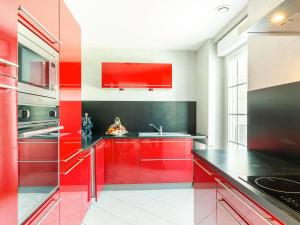 une cuisine rouge avec des comptoirs noirs et des armoires rouges dans l'établissement Holiday Home Villa Mor-Eol - PNR211 by Interhome, à Plounéour-Trez