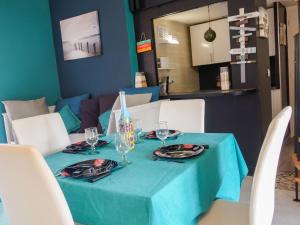 サン・シプリアン・プラージュにあるHoliday Home Mas del Sol by Interhomeの青いテーブルクロスとメガネのテーブル