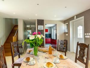 a dining room table with a vase of flowers on it at Holiday Home Villa Mor-Eol - PNR211 by Interhome in Plounéour-Trez