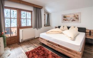 sypialnia z łóżkiem z białą pościelą i poduszkami w obiekcie La Tombola Appartements w mieście Gerlos