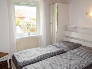 a bedroom with a bed and a window at Holiday Home Mee - hrzeit - HOK106 by Interhome in Hooksiel