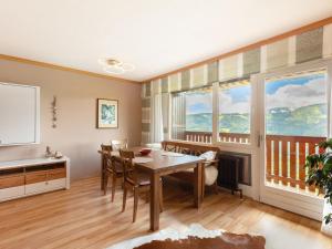 a dining room with a table and chairs and large windows at Apartment Appartement Andrea by Interhome in Grünholzer