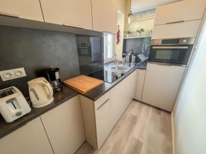 una pequeña cocina con fregadero y nevera. en Apartment Goélands by Interhome, en Biarritz