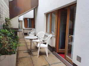 um pátio com cadeiras e uma mesa ao lado de um edifício em Apartment Chalet Abendrot-4 by Interhome em Grindelwald