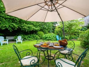 a table with an umbrella in a yard at Holiday Home La Haute Gilberdière - SIY400 by Interhome in Sartilly