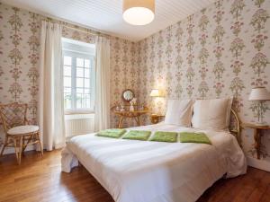 a bedroom with a large white bed with floral wallpaper at Holiday Home La Haute Gilberdière - SIY400 by Interhome in Sartilly