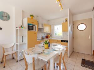 cocina y comedor con mesa blanca y sillas en Holiday Home Oscar - HSM402 by Interhome, en Hauteville-sur-Mer