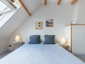 Un dormitorio con una cama grande con almohadas azules. en Holiday Home Les Mouettes by Interhome, en Hauteville-sur-Mer