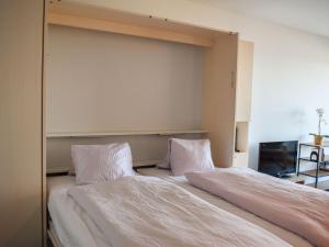 a bedroom with a bed with white sheets and pillows at Apartment Residenza Monte Bré - Apt-204 Haus2 by Interhome in Lugano