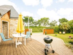 a patio with a table and an umbrella and a grill at Holiday Home Les Bambous by Interhome in Guissény
