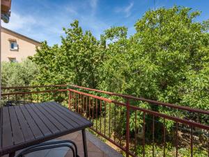 a balcony with a wooden table and some trees at Apartment Giuliano-2 by Interhome in Frata