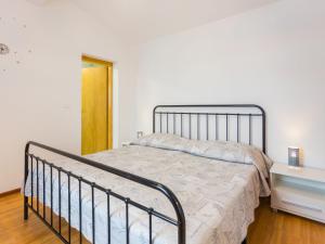 Bett in einem weißen Zimmer mit Bettrahmen in der Unterkunft Holiday Home Sandra by Interhome in Rajki