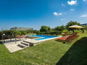 an image of a swimming pool with chairs and an umbrella at Holiday Home Villa Emanuela - IPC100 by Interhome in Pićan