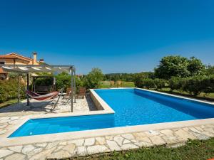 a swimming pool with a table and a chair at Holiday Home Villa Emanuela - IPC100 by Interhome in Pićan