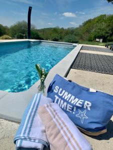 a pair of towels sitting next to a swimming pool at Domaine de la Jarrige in Saint-Vaury