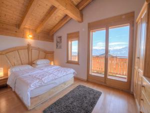 ein Schlafzimmer mit einem Bett und einem großen Fenster in der Unterkunft Chalet Campanule by Interhome in Anzère