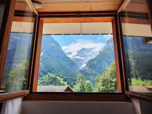 a window in a room with a view of mountains at Apartment Chalet Abendrot-21 by Interhome in Grindelwald