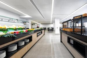a kitchen with counters with plates and fruits and vegetables at Hotel Parque La Paz in Playa de las Americas