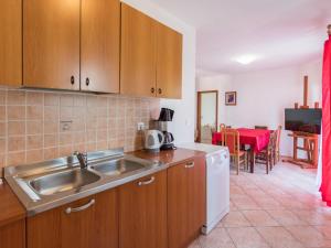 a kitchen with a sink and a kitchen with a table at Apartment Giuliano-4 by Interhome in Frata
