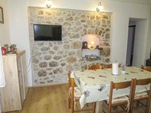 Un comedor con una mesa y una pared de piedra. en Holiday Home Marija by Interhome, en Starigrad-Paklenica