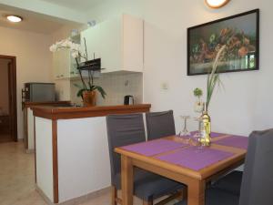een keuken met een houten tafel en een tafel met stoelen bij Apartment Mirjana-1 by Interhome in Ružići +26 foto's