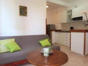 een woonkamer met een bank en een tafel bij Apartment Mirjana-1 by Interhome in Ružići