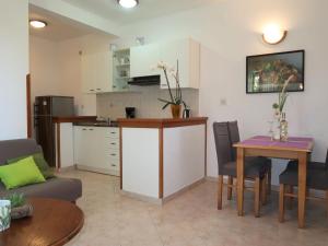 een keuken en een woonkamer met een tafel en stoelen bij Apartment Mirjana-1 by Interhome in Ružići