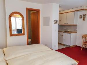 グリンデルワルトにあるApartment Chalet Abendrot-2 by Interhomeの小さなベッドルーム(ベッド1台付)、キッチンが備わります。