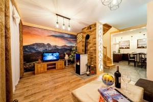 a living room with a large painting on the wall at Komfortowe domki na wynajem - Holiday Tatry in Poronin