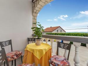 a table with a yellow table cloth and chairs on a balcony at Apartment Brzic - CKV105 by Interhome in Crikvenica